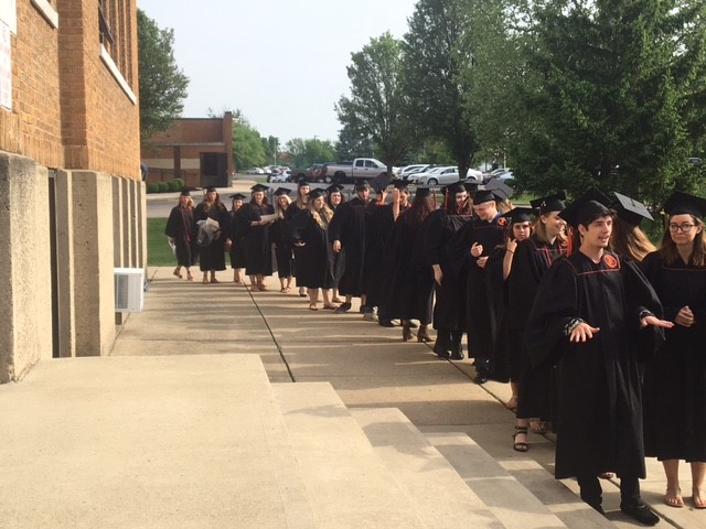 graduates in a line outside a building